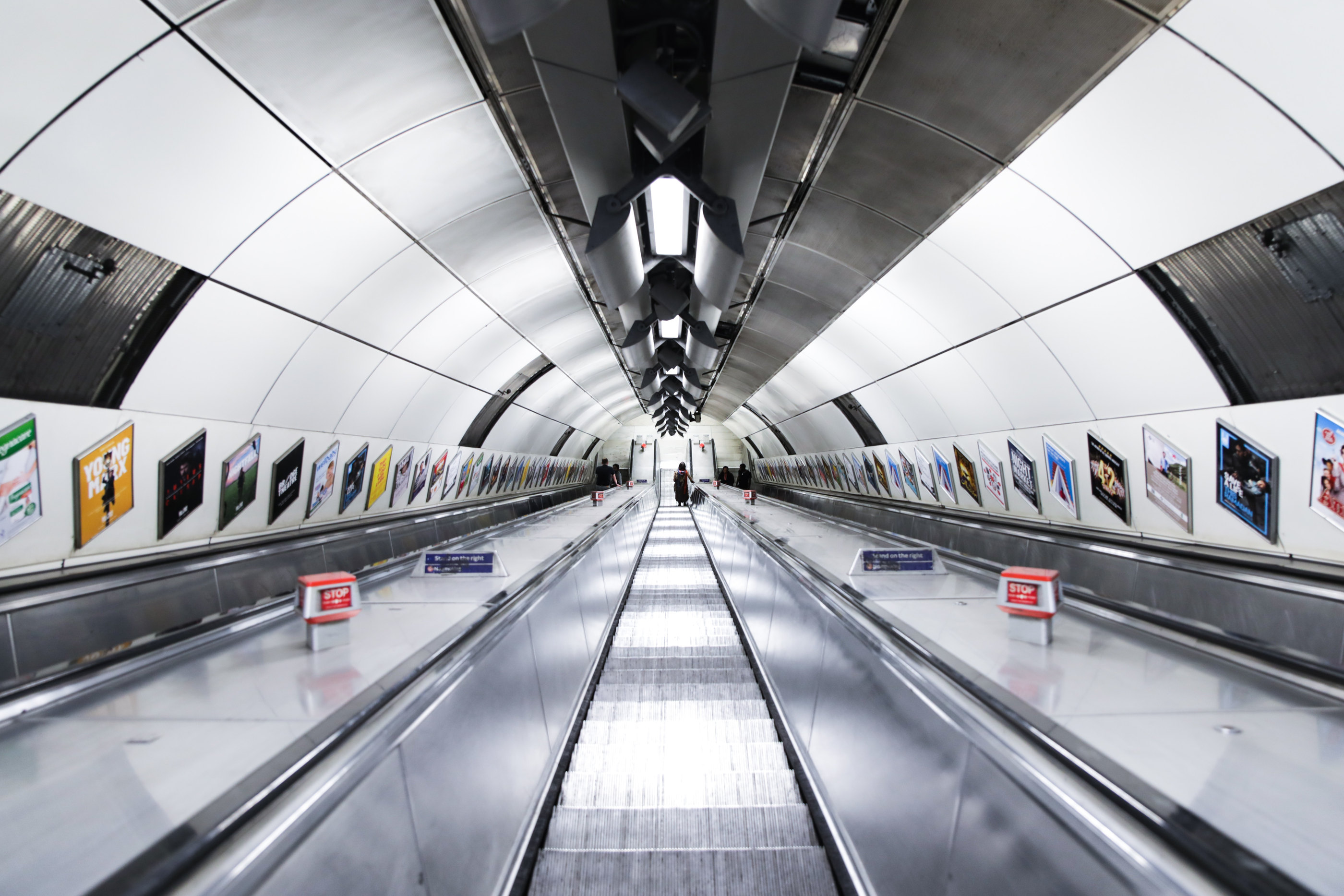 A long metro tunnel lined with advertising panels