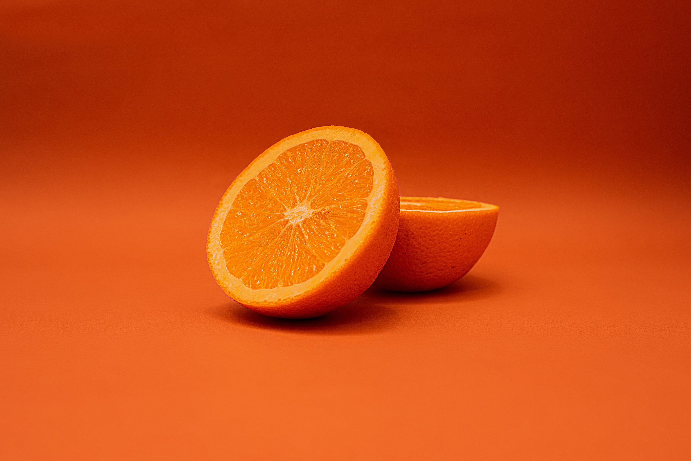 A halved orange on a bright orange background