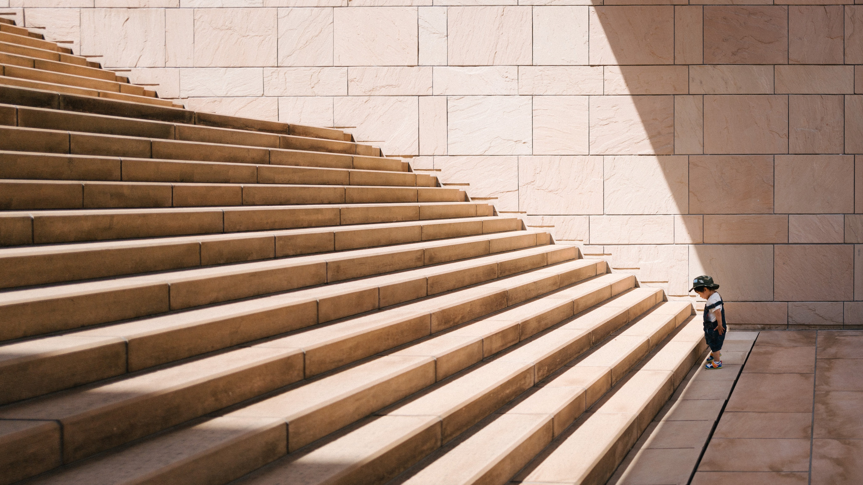 A child stepping up a wide flight of stone stairs