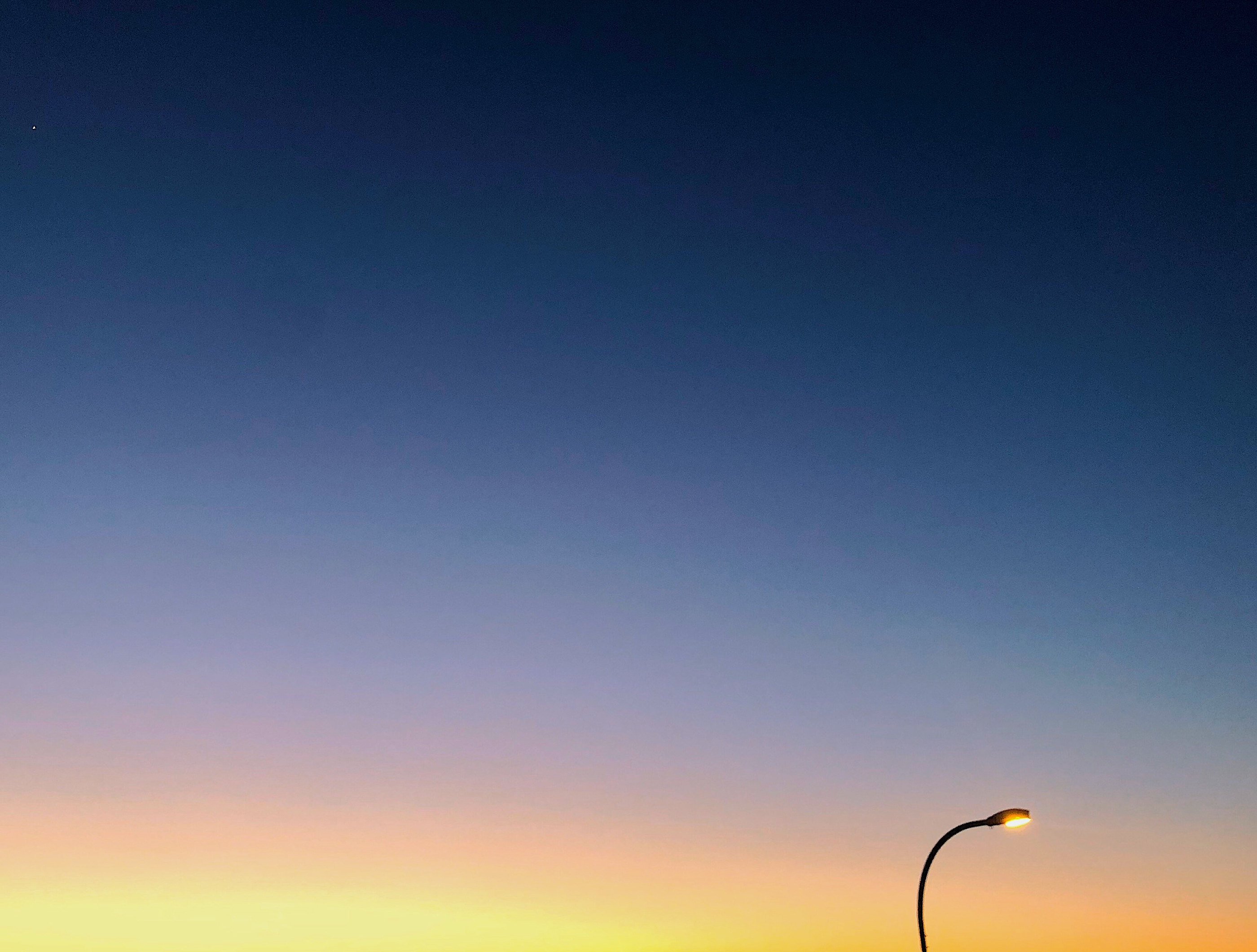 A lone street lamp against a gradient dusk sky