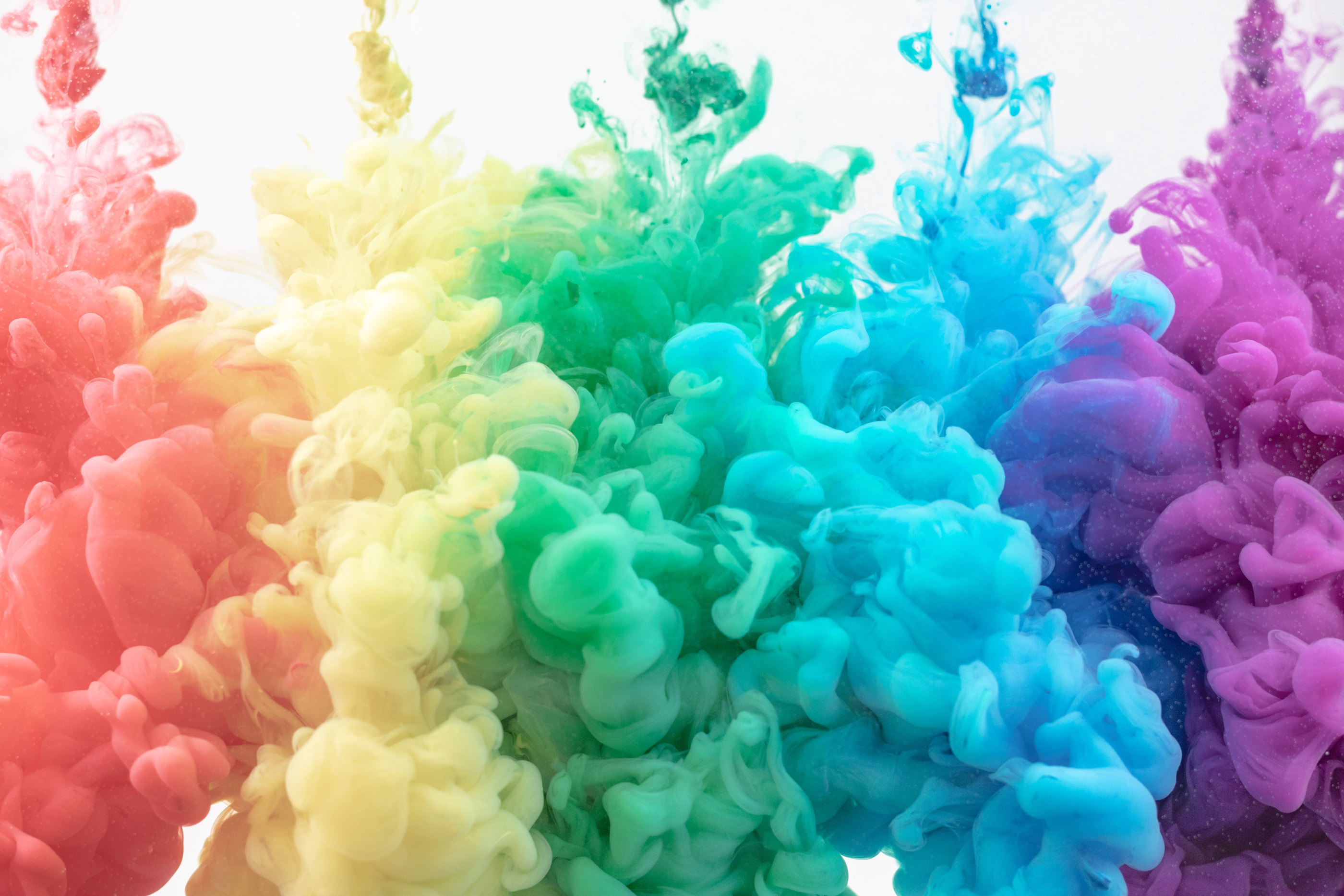 Rainbow-coloured ink blooming in water