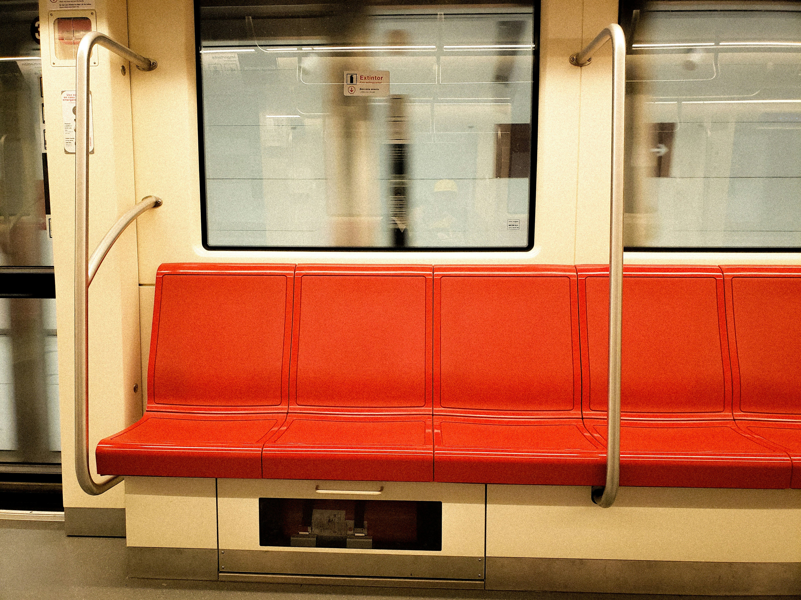 An empty train carriage with red seats
